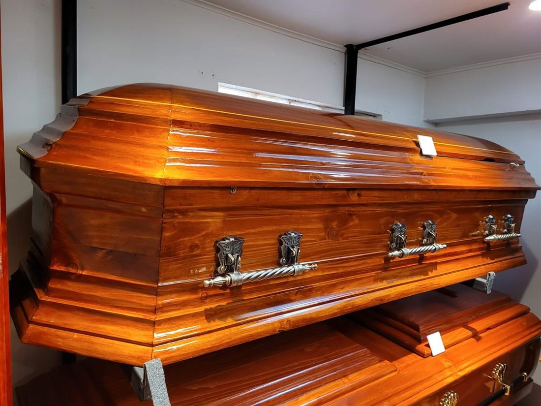 Ataúd de madera clara con herrajes plateados
